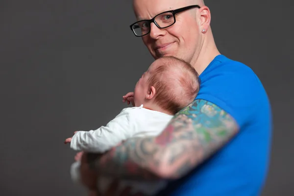 Papá feliz con gafas sosteniendo a su bebé. Captura de estudio . —  Fotos de Stock