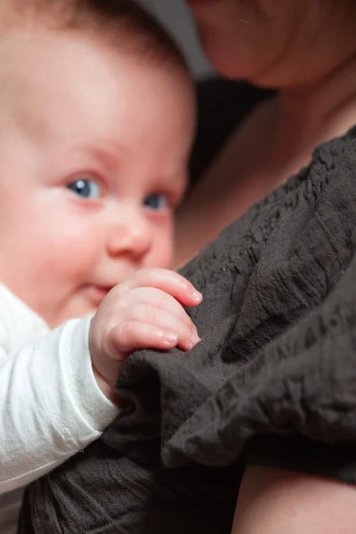 ママの腕の中で赤ん坊の娘。スタジオ撮影. — ストック写真
