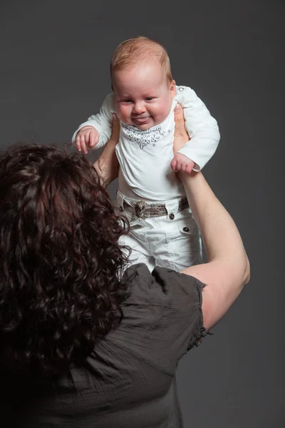 Baby daughter in the arms of mom. Studio shot. — Stock Photo, Image
