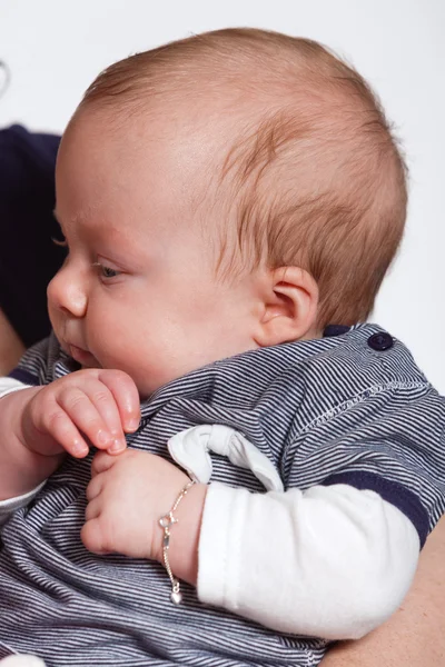 Baby in arm of mother. Closeup. Studio shot. — Stock Photo, Image