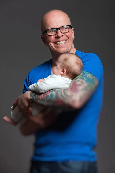 Papá feliz con gafas sosteniendo a su bebé. Captura de estudio . —  Fotos de Stock