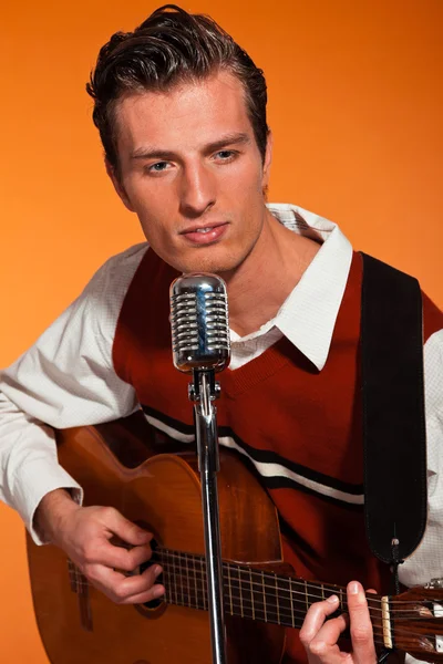 Retro fifties rock and roll singer playing accoustic guitar. Stu — Stock Photo, Image