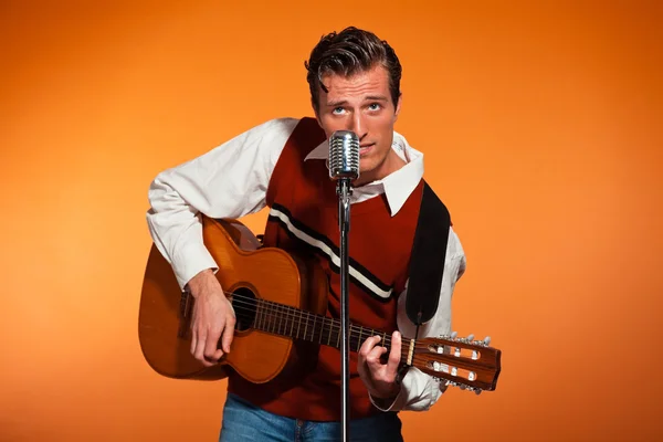 Retro fifties rock and roll singer playing accoustic guitar. Stu — Stock Photo, Image