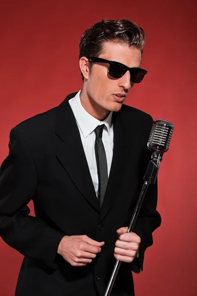 Retro fifties singer with vintage microphone and sunglasses. Stu — Stock Photo, Image