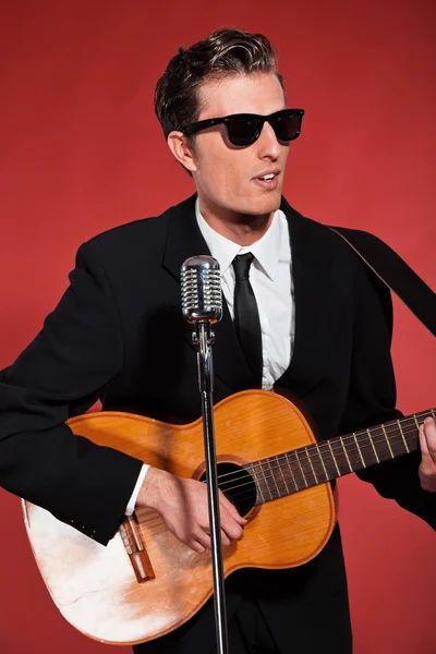 Retro ellili şarkıcı akustik gitar çalmaya güneş gözlüklü. St — Stok fotoğraf