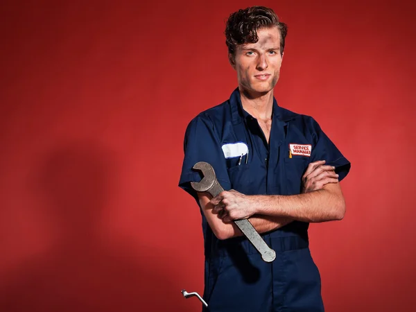 Retro fifties male car mechanic holding tool. Studio shot. — Stock Photo, Image