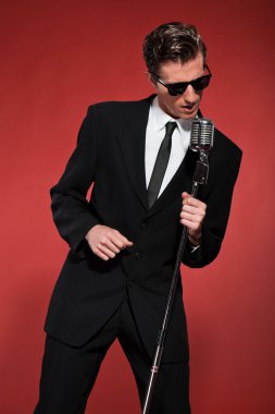 Retro fifties singer with vintage microphone and sunglasses. Stu