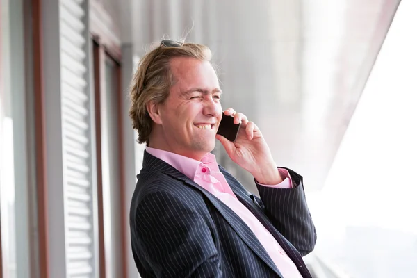 Exitoso hombre de negocios llamando con teléfono celular al aire libre en el balcón —  Fotos de Stock