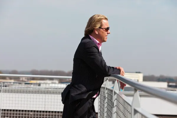 Geschäftsmann mit Sonnenbrille draußen auf dem Dach eines Bürogebäudes — Stockfoto
