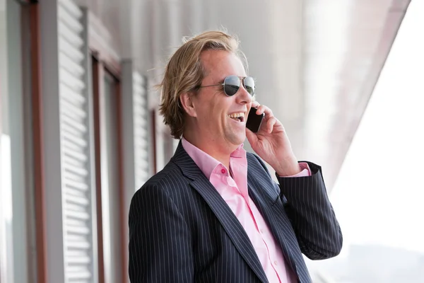 Homme d'affaires avec lunettes de soleil appelant avec téléphone portable en plein air sur b — Photo