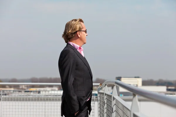 Hombre de negocios con gafas de sol al aire libre en la azotea del edificio de oficinas —  Fotos de Stock