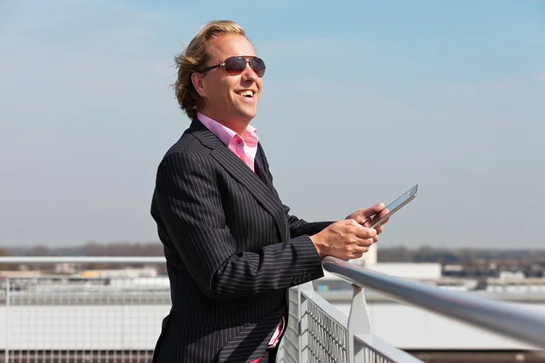 Homme d'affaires avec des lunettes de soleil en plein air sur le toit en utilisant une tablette . — Photo