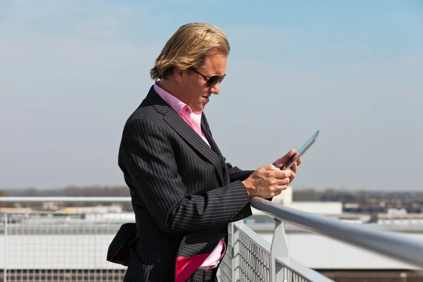 Business man with sunglasses outdoor on rooftop using tablet. — Stock Photo, Image