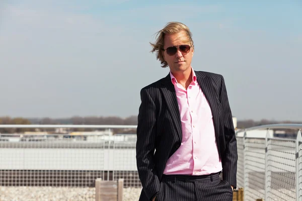 Uomo d'affari con occhiali da sole all'aperto sul tetto di un edificio per uffici — Foto Stock