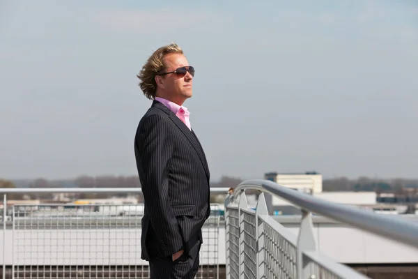 Zakenman met zonnebril buiten op dak van office buildi — Stockfoto