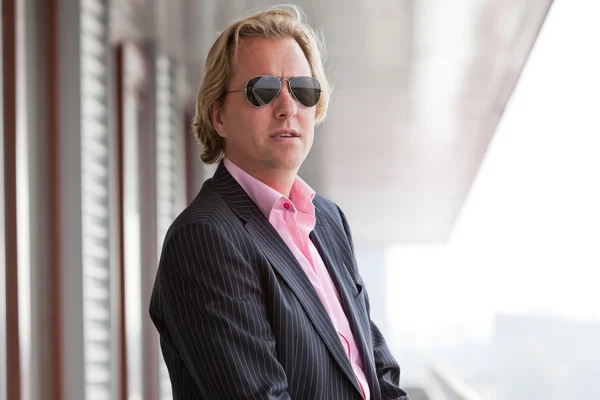 Business man with sunglasses on balcony of office. — Stock Photo, Image