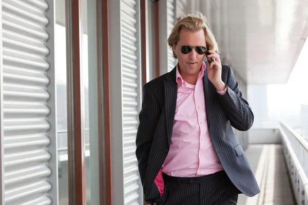 Ο άνθρωπος των επιχειρήσεων με γυαλιά ηλίου κλήση με κινητό τηλέφωνο υπαίθρια στο o — Φωτογραφία Αρχείου