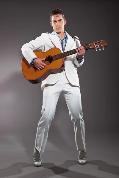 Retro rock and roll male guitar player wearing white suit. Studi — Stock Photo, Image