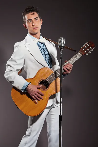 Retro rock and roll singer with guitar wearing white suit. Studi — Stock Photo, Image