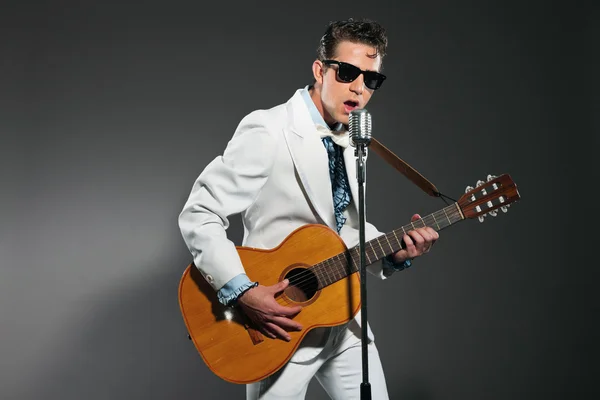 Chanteuse rock and roll rétro en costume blanc et lunettes de soleil noires — Photo