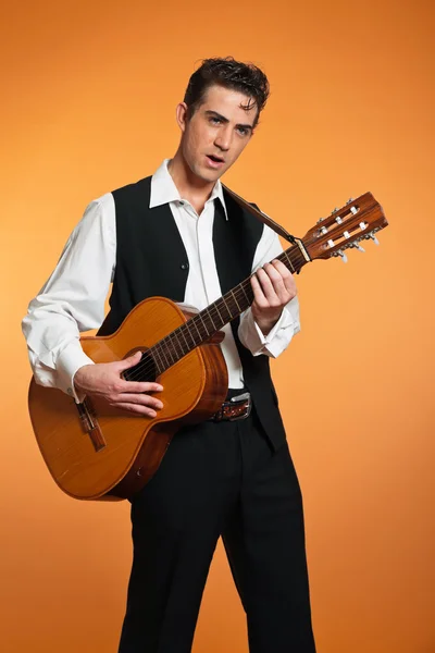 Retro country male guitar player wearing black suit. Studio shot — Stock Photo, Image