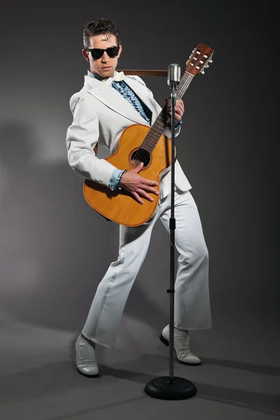Retro rock and rollového zpěváka na sobě bílé barvy a černé brýle白いスーツと黒のサングラスを着てレトロなロックン ロールの歌手 — ストック写真