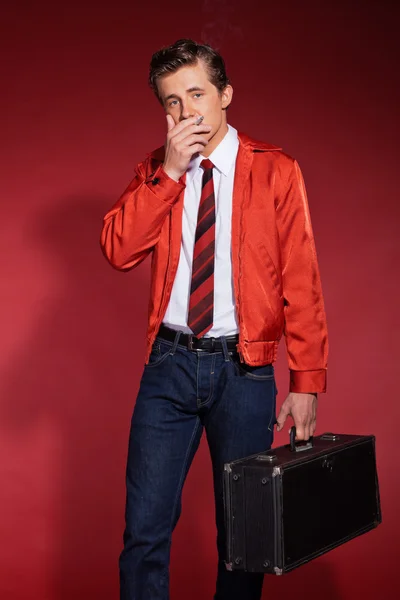 Retro fifties fashion man wearing red jacket and jeans. Holding — Stock Photo, Image