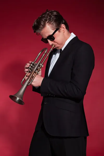 Retro trompetista dos anos cinquenta vestindo terno preto e óculos de sol . — Fotografia de Stock