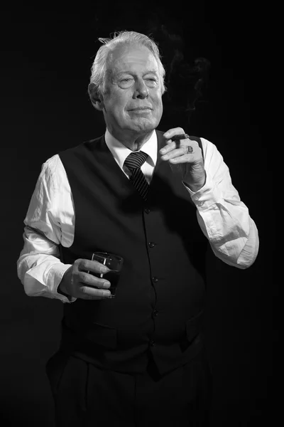 Retro hombre de negocios senior con whisky fumando cigarro. Negro y w —  Fotos de Stock