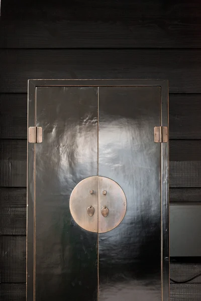 Armoire de style japonais noir debout contre un mur en bois noir . — Photo