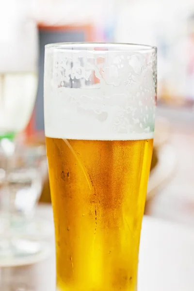 Jednej szklanki zimnego piwa. odkryte na stół. — Zdjęcie stockowe