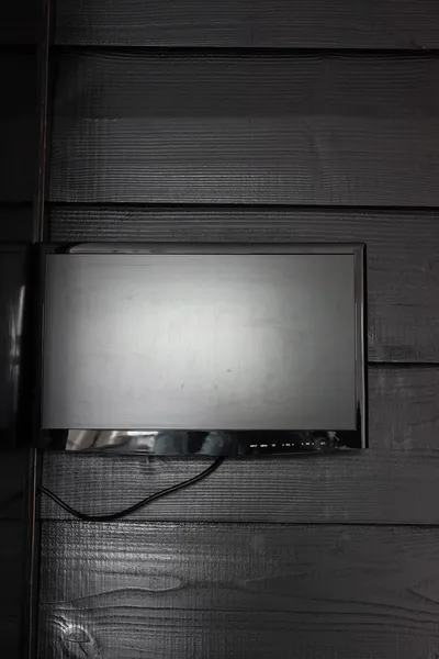 TV tela plana preta na parede de madeira preta . — Fotografia de Stock