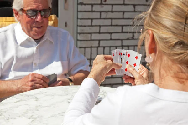 Coppia di anziani gioco di carte all'aperto in giardino . — Foto Stock