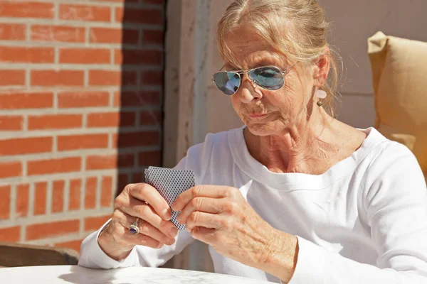 Senior mulher jogando jogo de cartas ao ar livre no jardim . — Fotografia de Stock