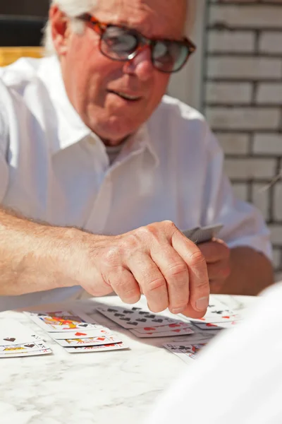 Äldre man spela kortspel utomhus i trädgården. — Stockfoto