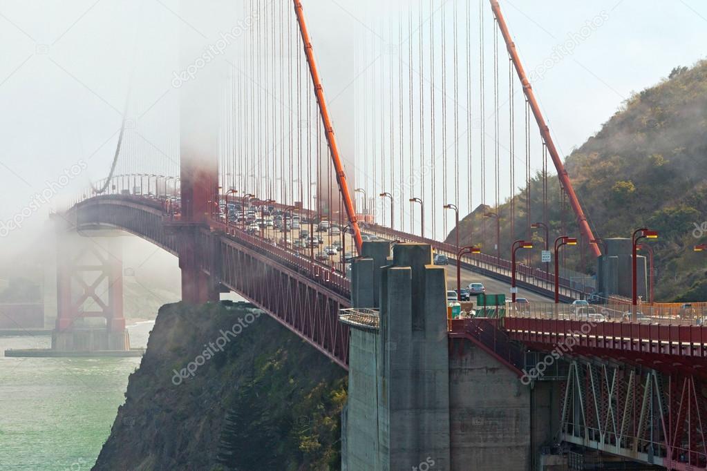 Close-up of Golden Gate Bridge with traffic. Cloudy sky. San Fra
