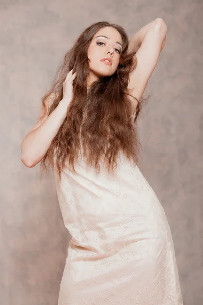 Sensual fashion woman with long hair. Wearing beige dress. Marbl — Stock Photo, Image