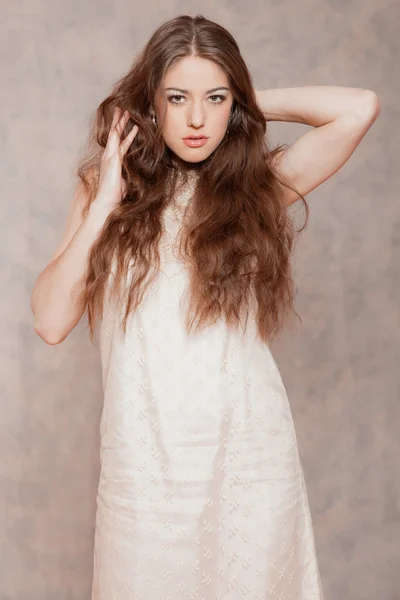 Sensual fashion woman with long hair. Wearing beige dress. Marbl — Stock Photo, Image