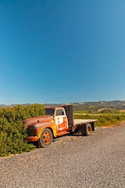 Velho caminhão pickup enferrujado em pé na paisagem adega com sk azul — Fotografia de Stock