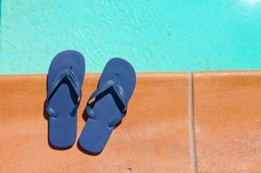 havuz kenarındaki mavi terlik bir çift.