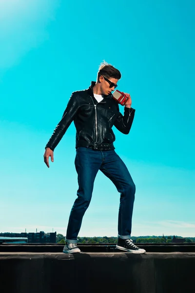 Rockabilly man 50s retro stijl met zwarte jas luistert op poort — Stockfoto