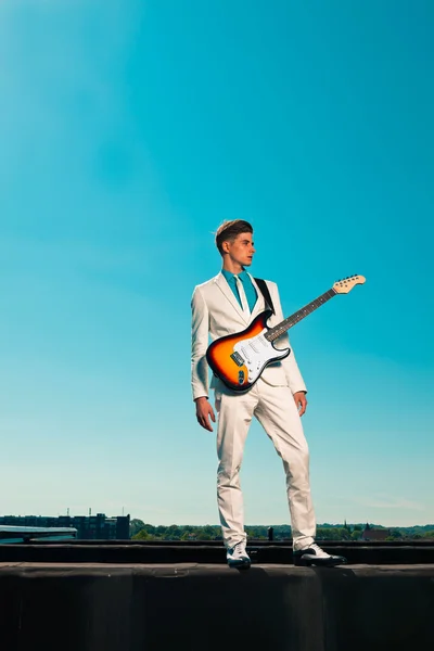 50iger Jahre männlicher E-Gitarrist mit weißem Anzug. auf dem Dach — Stockfoto
