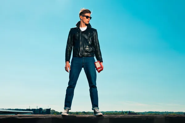 Rock and roll man 50s style with black jacket. Holding portable — Stock Photo, Image