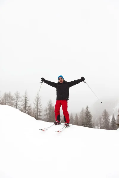 Homem de esqui feliz com chapéu azul em pé na neve . — Fotografia de Stock