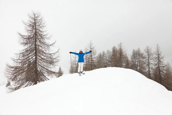 松の木に雪の中で立って幸せスキー女性. — ストック写真