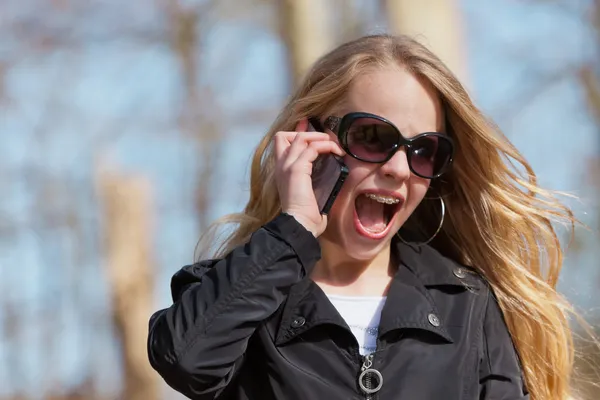 Jonge blonde meisje met zonnebril in park bellen met cellphone — Stockfoto