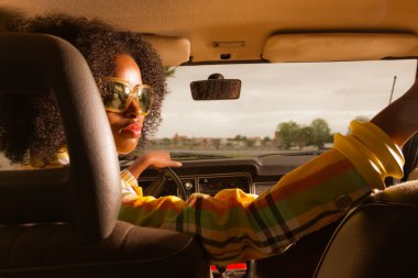 retro 70'lerin kahverengi se sürüş güneş gözlüklü kadın afro moda