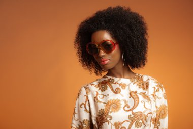 retro 70'lerin desenli elbise ve sunglasse ile Afrikalı kadın moda