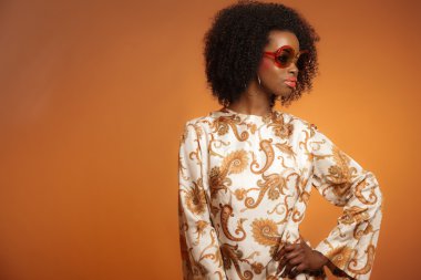 retro 70'lerin desenli elbise ve sunglasse ile Afrikalı kadın moda