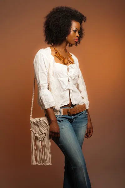 Vintage 70s fashion afro woman. White shirt and jeans against br — Stock Photo, Image